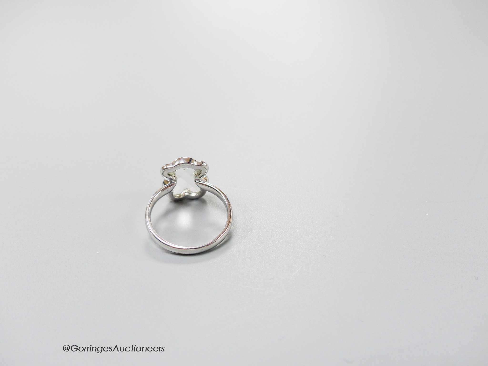 A modern Tous 750 white metal and facetted rock crystal dress ring, with diamond chip set border, size J, gross weight 3 grams.